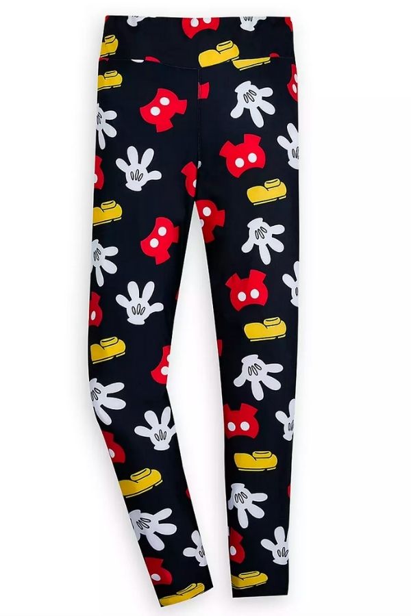 A black pair of leggings with images of Mickey's shorts, gloves, and shoes in red, white, and yellow.