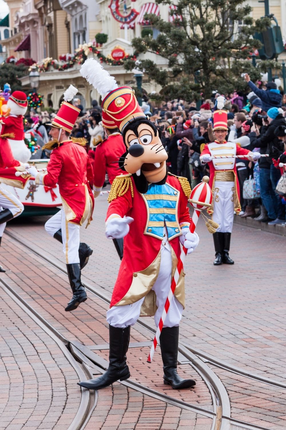 Goofy, a fur character (or masked character) marches in a holiday parade at Disney World