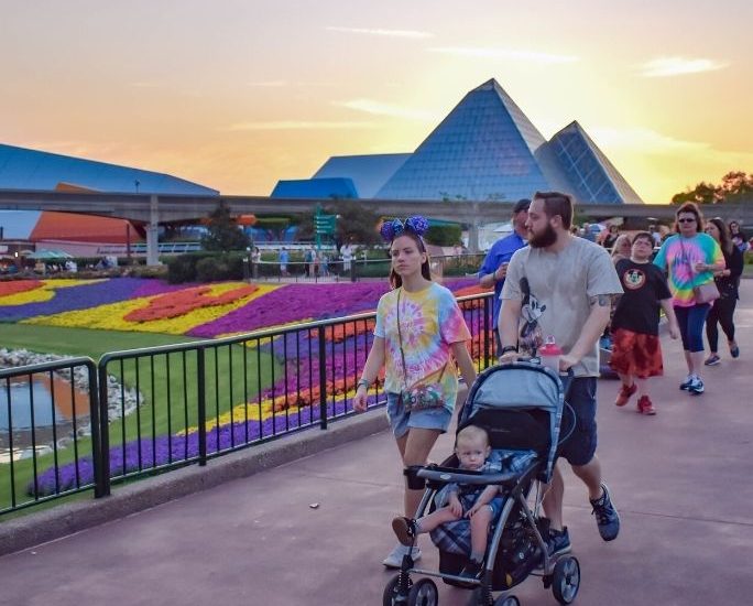 a man and woman visit disney with a toddler in a stroller