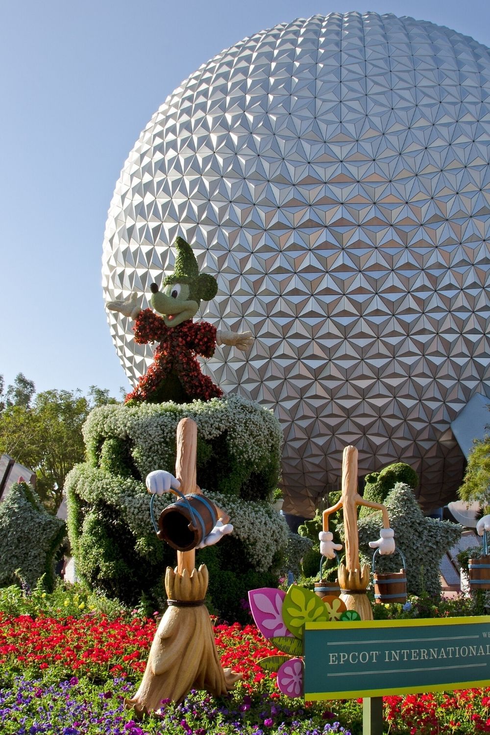 Spaceship Earth at Epcot, with a Mickey topiary in front.