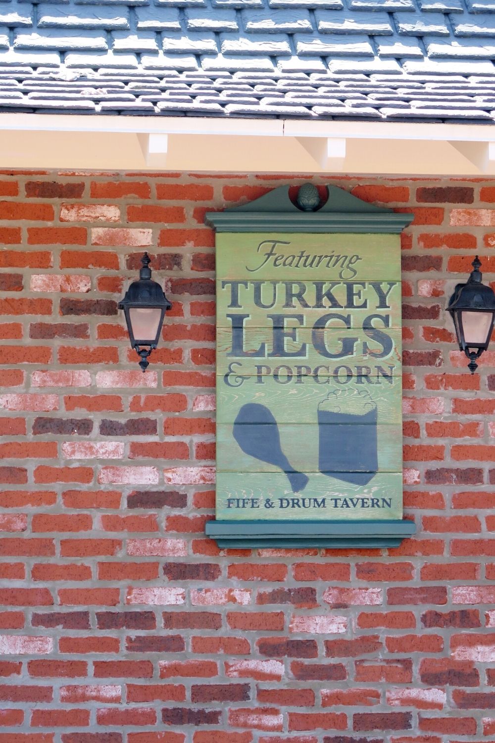 a sign at Epcot's Fife and Drum Tavern, advertising turkey legs and popcorn