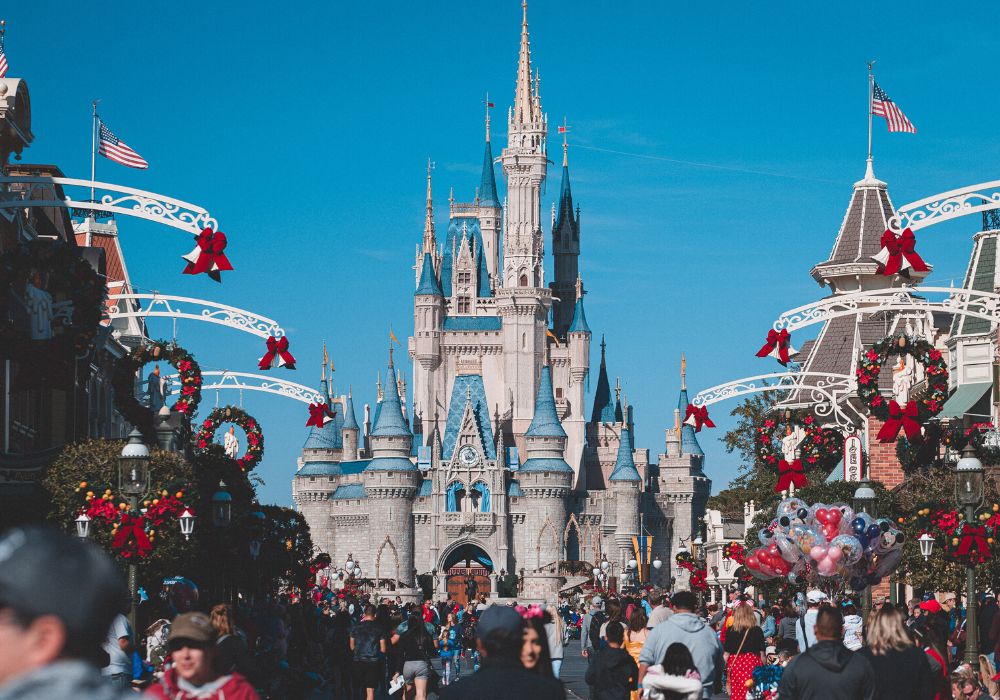 Cinderella's Castle at Disney World, with Christmas wreaths and decor surrounding it on Main Street USA