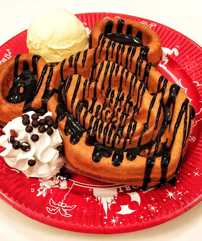 Mickey waffle topped with chocolate syrup