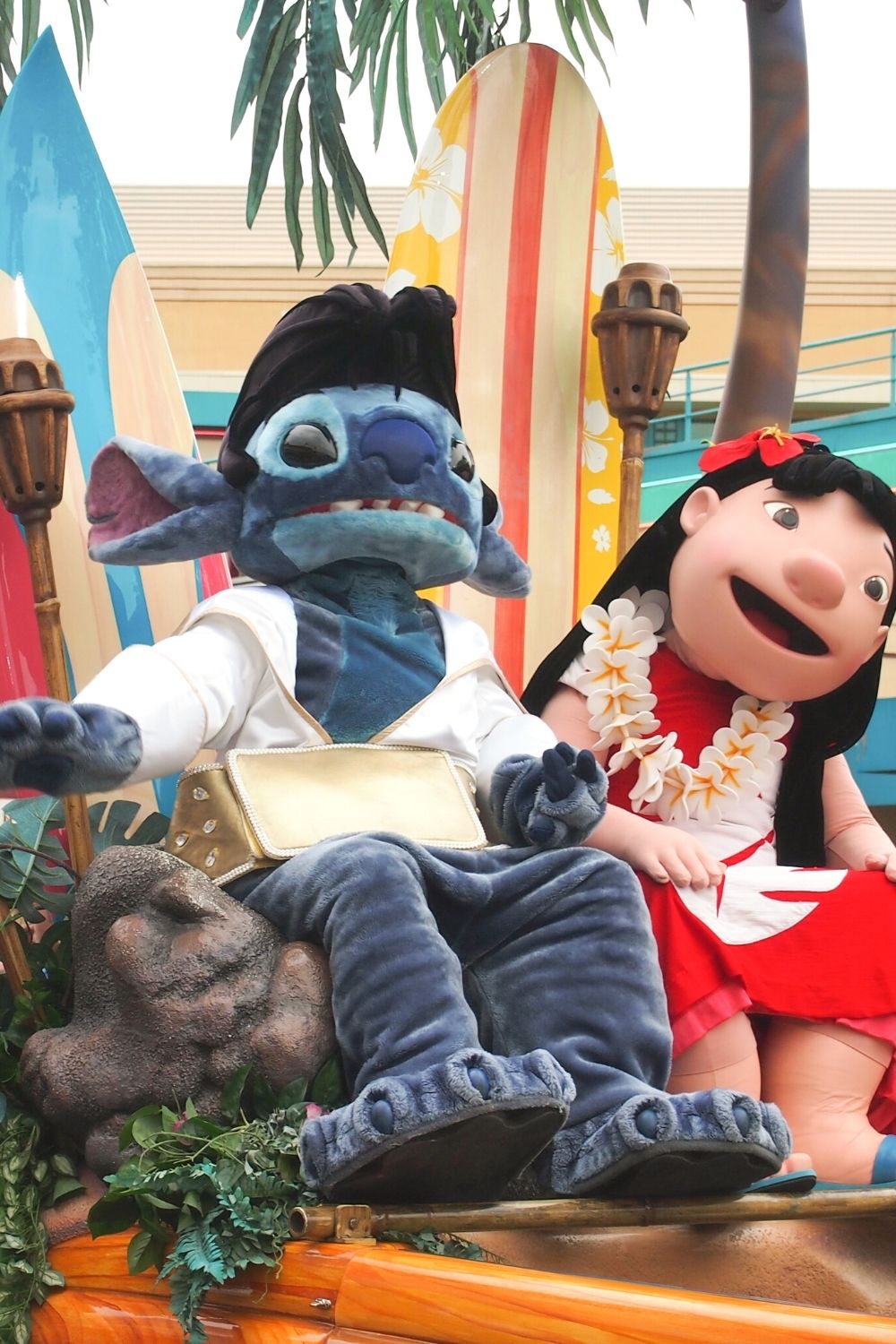 A Disney parade float features Lilo and Stitch characters, with Stitch in an Elvis suit